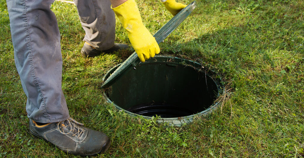 Image of a man opening a septic tank cover