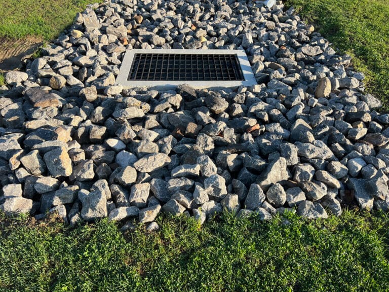 Drain rock around a metal grate drain